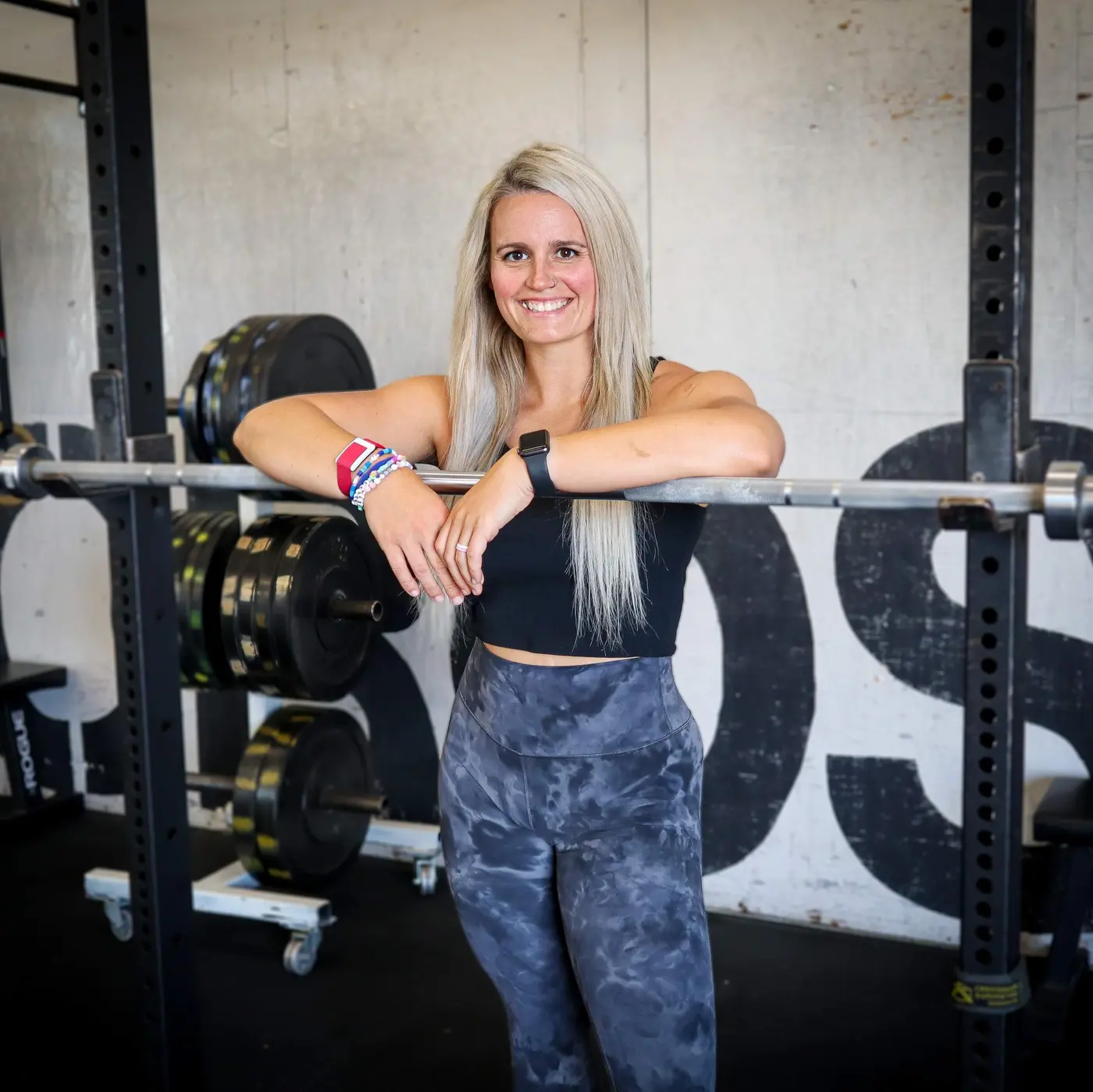 Susie Fong smiling in a gym beside a barbell